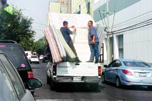 ( MÉXICO - DF, Nov 2015 ) Trabajadores que recolectan el "Fierro Viejo" arriesgan su vida transportandose en pequeñas camionetas, llenas de estufas, refrigeradores y colchones viejos.