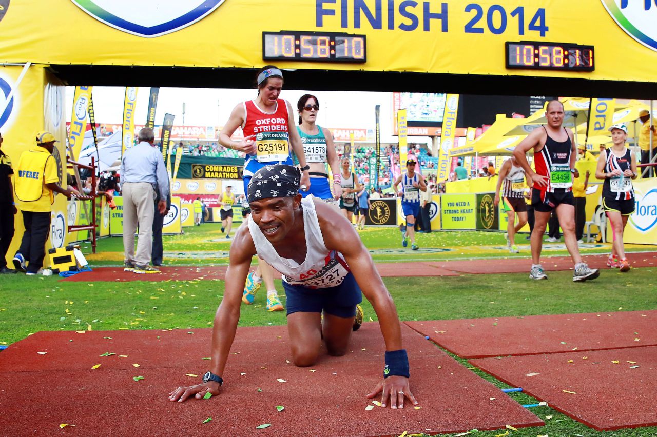 An exhausted Comrades Marathon runner collapses as he arrives at the finishing line at the end of the 89km Comrades Marathon between Pietermaritzburg and Durban on June 1, 2014, in Durban, South Africa. AFP PHOTO / RAJESH JANTILAL        (Photo credit should read RAJESH JANTILAL/AFP/Getty Images)