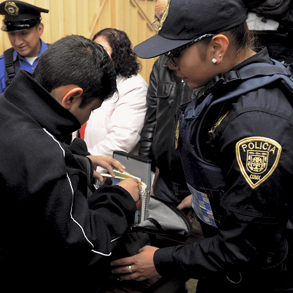 Policías revisan las mochilas de estudiantes de nivel básico durante el operativo Mochila Segura. Foto, Cuartoscuro.