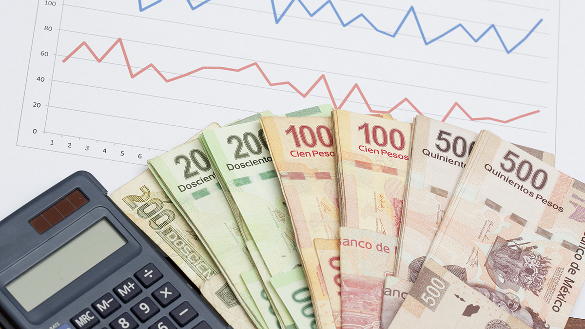 Mexican peso banknotes and chart data analysis on stock market or sales. Business concept image. Stack of Mexican pesos and calculator.
