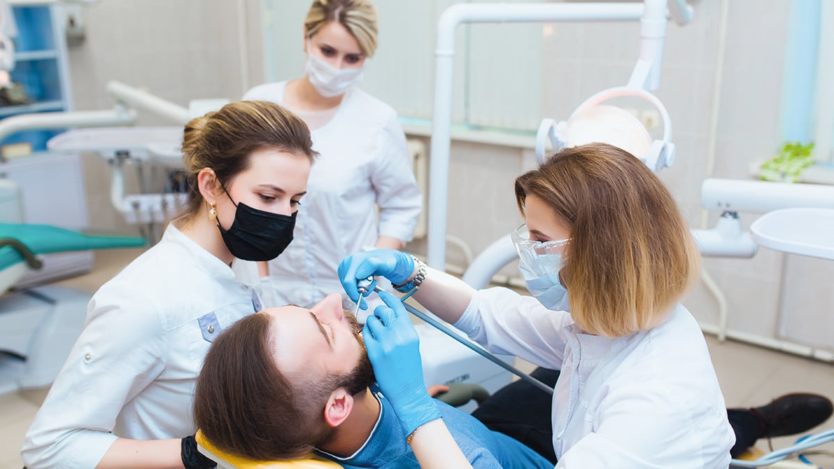 Young professional doctor dentist in a modern office with dental equipment. The concept of health insurance and free dental care. Prosthetics and installation of veneers.