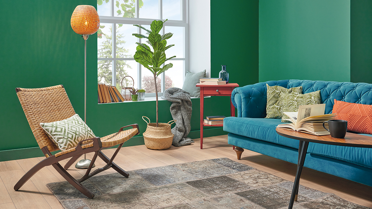 Green and white living room concept, blue sofa orange pillow, middle coffee table, vase of plant, carpet and brown parquet, lamp home decoration style.